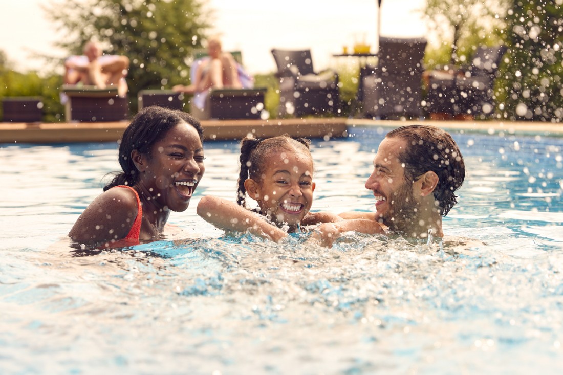A family splashes around in a residential pool at a Tuscon manufactured home community. 